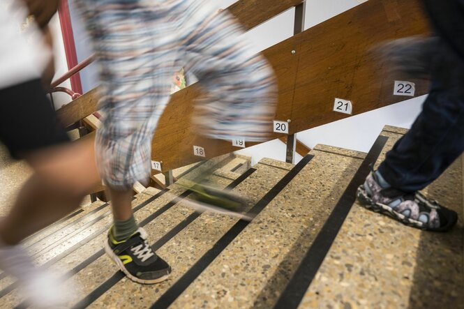 Kiner rennen die Treppe hoch, es sindnur ihre Beine zu sehen, am Rand der Treppe stehen Zahlen