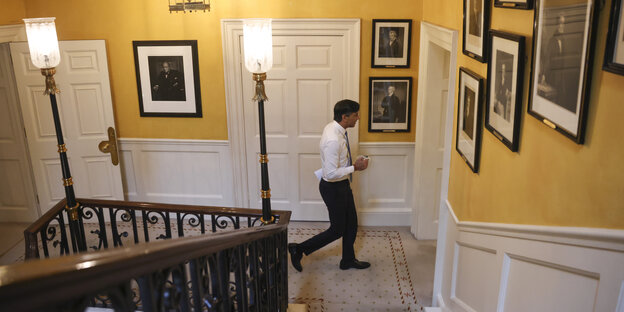 Sunak läuft in den Räumen der Downing Street an Schwarz-Weiß-Portraits vorbei