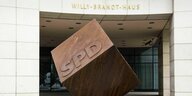 Ein Würfel aus Stahl mit den Buchstaben SPD steht auf der Spitze vor dem Eingangsbereich des Willy-Brandt Hauses in Berlin