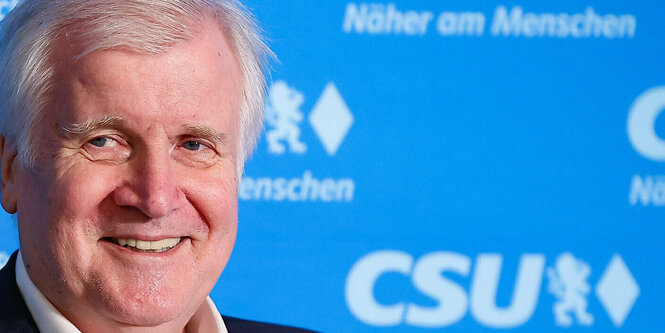 Horst Seehofer vor einer Wand, auf der "näher am Menschen" steht