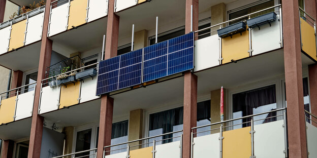 Ein Balkonkraftwerk mit Photovoltaikelemente an einer Wohnhausfassade mit Balkonen