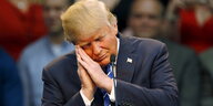 Donald Trump macht eine Geste als ob er schliefe.
