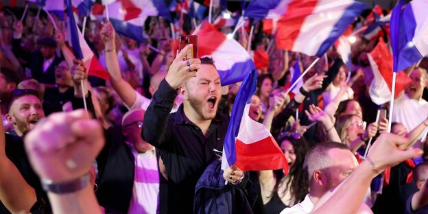 Anhänger des Rassemblement National jubeln, es werden viele französische Flaggen geschwenkt