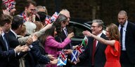 Der neue Premierminister Keir Starmer und seine Frau Victoria Starmer werden auf dem Weg nach Downing Street 10 von Labour-Anhänger*innen begrüßt.