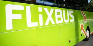In Nahaufnahme und Querformat zu sehen ist ein Bus der Firma Flixtrain, giftgrün mit dem großen Schriftzug "Flixbus" auf der Seite.