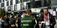 Protest vor der Universität in Lausanne, die Flaggen Palästinas werden geschwenkt und ein Teilnehmer trägt ein T-Shirt mit der Aufschrift: Boycott Israel