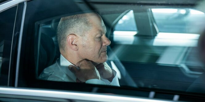 Bundeskanzler Olaf Scholz (SPD), sitzt nach einer Pressekonferenz zum Haushaltsplan 2025 in einer Limousine.