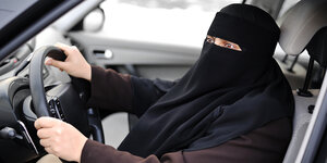 Eine Frau mit Niqab am Steuer eines Autos. Symbofoto