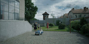 Familienidylle vor Betonwand. Interessant an diesem Bild ist, was man nicht sieht: das Leid in Auschwitz