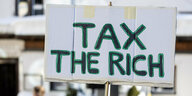 „Tax the Rich“ steht auf einem Plakat