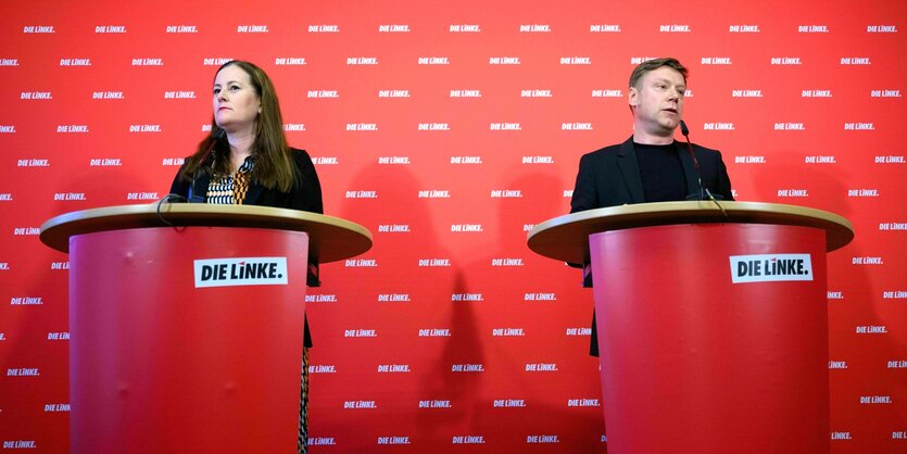 Janine Wissler und Martin Schirdewan stehen an Rednerpulten vor einer roten Wand