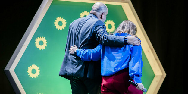 Die Parteivorsitzenden Omid Nouripour und Ricarda Lang verlassen mit den Rücken zur Kamera gewandt die Bühne der Grünen-Wahlparty in Berlin