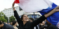 Eine Frau schwenkt die französische Flagge
