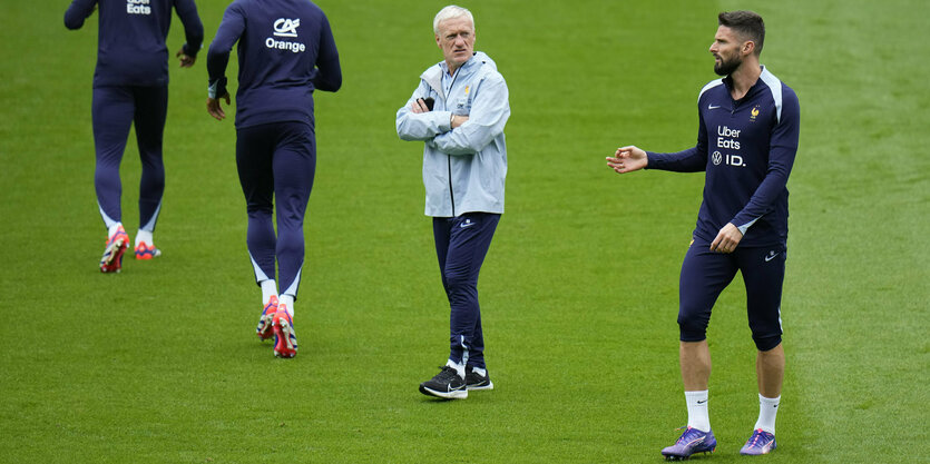 Frankreichs Trainer mit drei Spielern auf dem Trainingsplatz