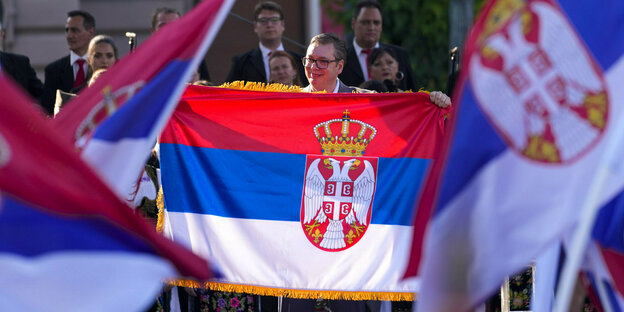 Der serbische Präsident zwischen serbischen Fahnen