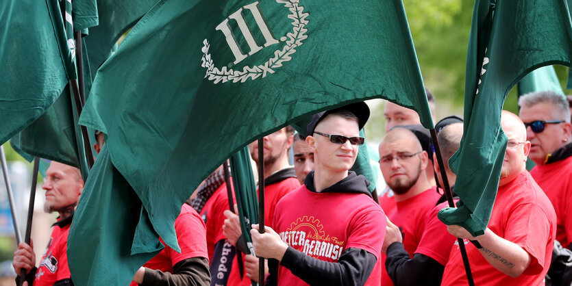 Nazis vom Dritten Weg bei einer Demo in roten Shirts und mit grünen Fahnen