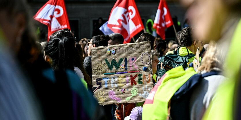 Vor dem Berliner Abgeordnetenhaus hält ein Kind ein Schild mit der Aufschrift ·Wir streiken· bei der Kundgebung streikender Kita-Erzieherinnen.