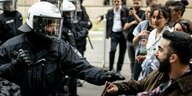 Ein Polizist und ein Pro-Palästina-Demonstrant stehen sich gegenüber. Die Situation ist geladen. Beide schreien.