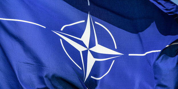 Eine blaue Fahne mit dem Logo der NATO
