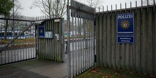 Ein offenes Zufahrtstor, am Schild steht "Polizei, Polizeiakademie"