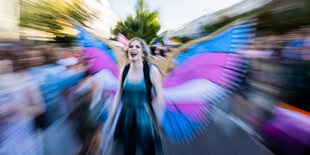 Teilnehmerin des Dyke* March mit Federkostüm