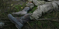 ein russischer Soldat liegt auf dem Boden, man sieht seine Stiefel und seine Uniformhose
