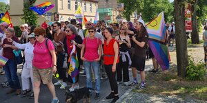 Menschen mit Regenbogenflaggen beim CSD in Rheinsberg