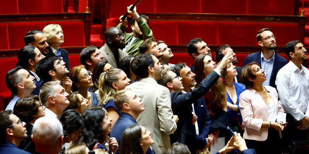 Abgeordnete besuchen den Plenarsaal in Frankreich, sie stehen vor leeren Rängen