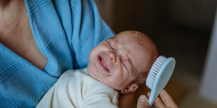 Ein Baby wird gebürstet.