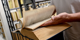 Roland Pape, Fachangestellter für Medien und Information, trocknet und kontrolliert Bücher auf Feuchtigkeit in der Zentral- und Landesbibliothek Berlin nach einem Wasserschaden.