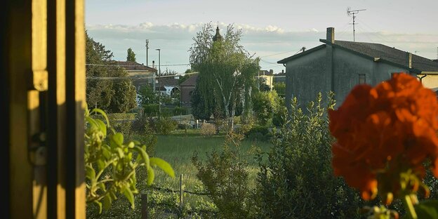 Blick aus dem Fenster auf einen Garten in einem italienischen Dorf