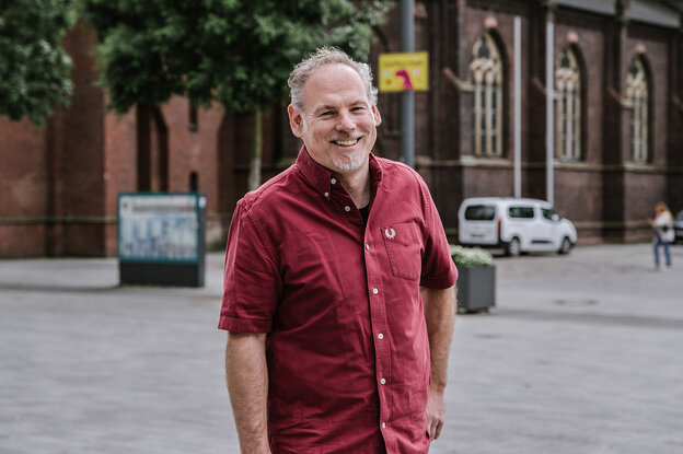 Dirk Slawetzki im roten Hemd vor einem Kirchengebäude