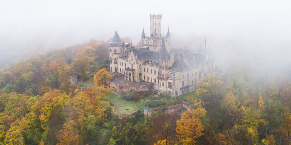 Nebelschwaden ziehen über das Schloss Marienburg in der Region Hannover hinweg. (Luftaufnahme mit einer Drohne).