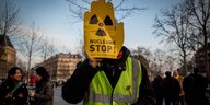 Demonstrant versteckt seinen Kopf hinter einem gelben Anti-Atomplakat