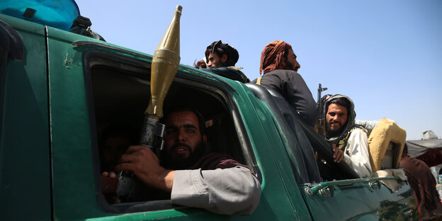Einige Taliban in und auf einem Pickup in Kabul