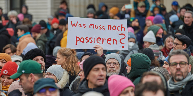 Demobild mit Schild „Was muss noch passieren?“