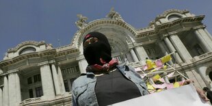 Ein Mitglied der indigenen Zapatistischen Nationalen Befreiungsarmee (EZLN) hält ein Plakat während einer Demonstration zum Internationalen Frauentag vor dem Palacio de Bellas Artes in Mexiko-Stadt, Mexiko, am 8. März 2016