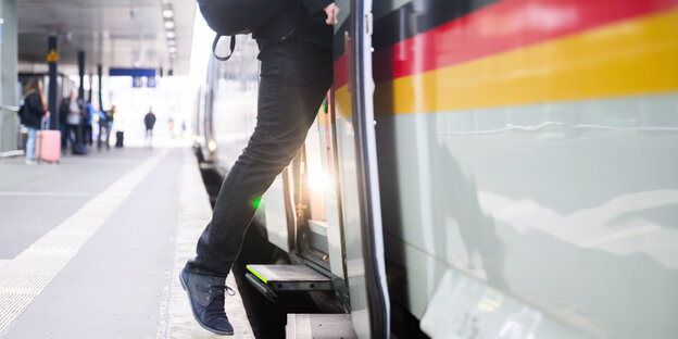 Ein Fahrgast steigt im Hauptbahnhof Hannover in den ICE „Bundesrepublik Deutschland“ mit umlaufender schwarz-rot-goldener Deutschlandfahne.
