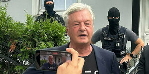 Jürgen Elsässer wird mit maskierten Polizisten fotografiert