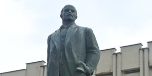 Ein bronzener Lenin vor einem Haus