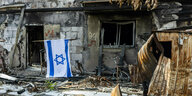 Blick auf ein zerstörtes Gebäude im Kibbutz Beer, ein Flagge Israels hängt vor dem Hauseingang