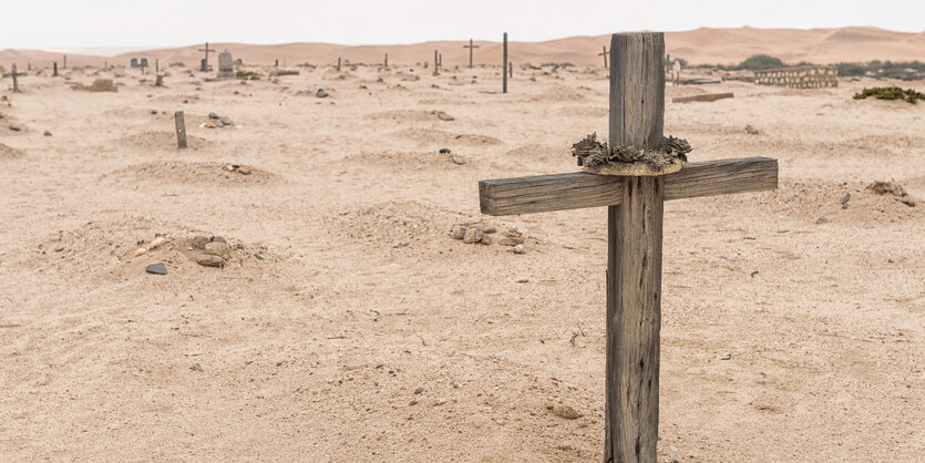 Holzkreuze auf sandigem Boden