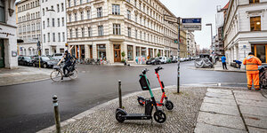 Straßenkreuzung in Berlin mit geparkten E-Rollern