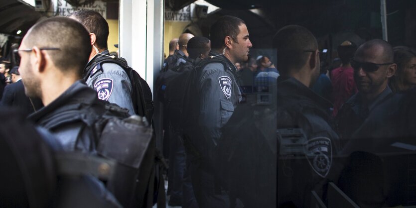 Polizisten stehen vor einem Fenster