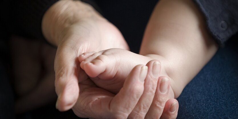 Kinderfuß in Erwachsenenhand