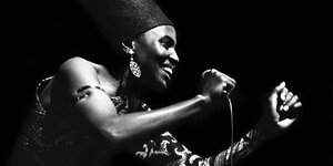 Schwarz-weiß-Aufnahme von Miriam Makeba, die in eine Mikrofon singt