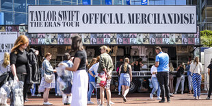 Fans von Taylor Swift stehen vor einem Merchandising-Stand