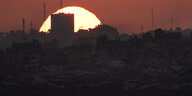Die Sonne geht hinter den Gebäuden im Gazastreifen unter, vom Süden Israels aus gesehen
