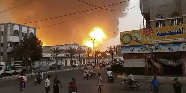 Flammen in der jemenitischen Hafenstadt Hodeida, davor Straßenszene.