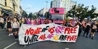 Menschen beim Internationalist Queer Pride Berlin Neukölln am 22. Juli 2023. Auf dem Fronttransparent steht: „None of us are free until all of us are free”.